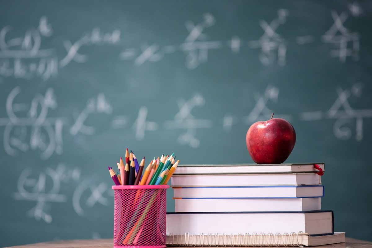 Libros, manzana y lápices en un salón de clases